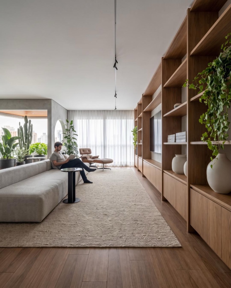 Open living room with floor-to-ceiling wooden shelving, light sofa and large window, rendered with Vizai